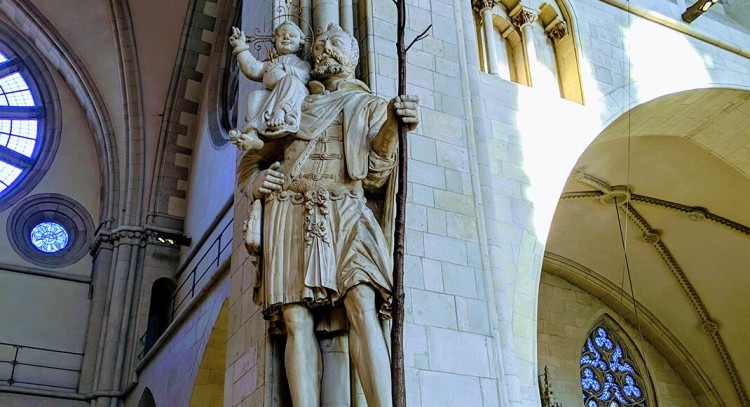 Statue of a medieval figure in the city of Münster with stone building