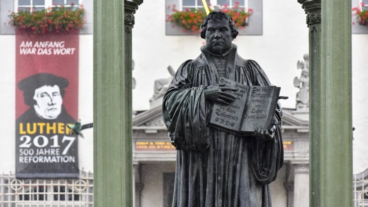 Statue of Martin Luther holding a book in black and white with blurred background