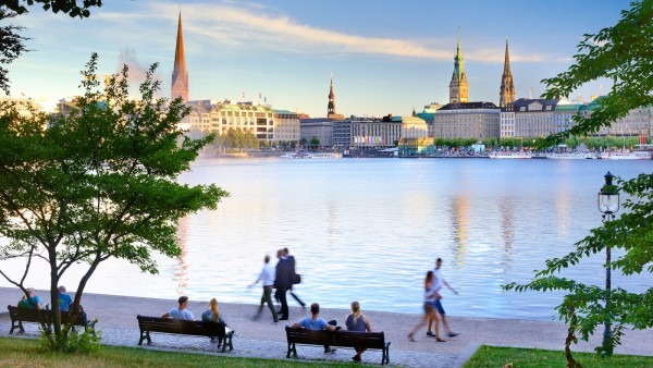 City promenade with people and church towers in the background under a clear sky